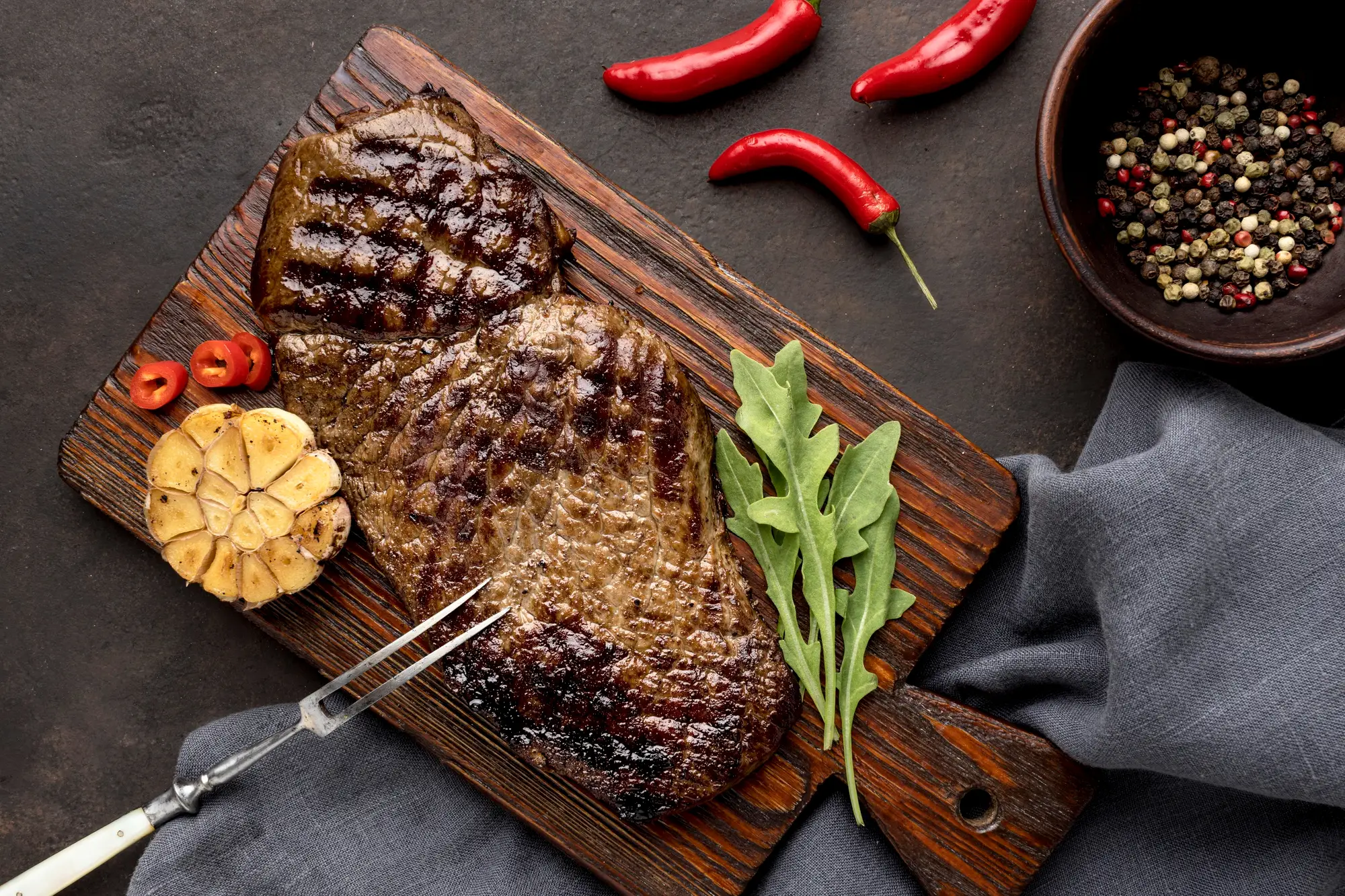 Grilled steak on a wooden board, seen from above